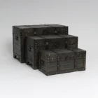 Set de 3 baúles de madera color gris oscuro con herrajes decorativos.